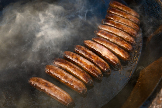 a bunch of sausages are cooking on a grill